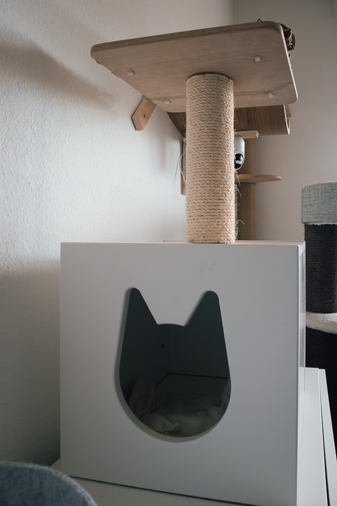 Eine IKEA Kallax-Katzenhöhle auf die ein Kratzbaumstamm mit einer Liegefläche montiert wurde.
